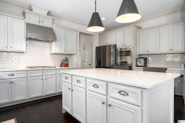 kitchen with pendant lighting, decorative backsplash, appliances with stainless steel finishes, light countertops, and under cabinet range hood