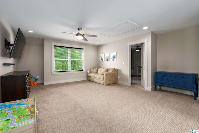 interior space with baseboards, attic access, a ceiling fan, and carpet
