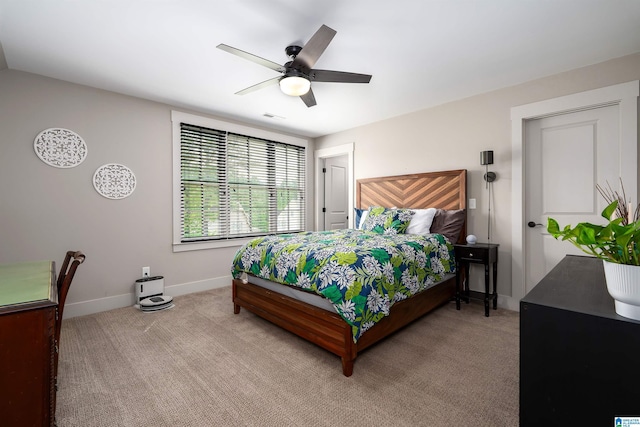 bedroom with baseboards, visible vents, ceiling fan, and light colored carpet