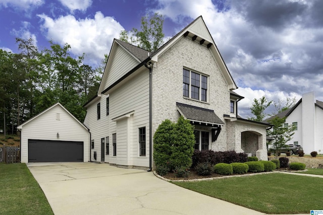 traditional-style home with an outdoor structure, a front lawn, a detached garage, and brick siding