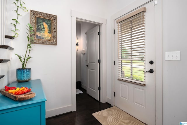 doorway to outside with dark wood-style floors and baseboards