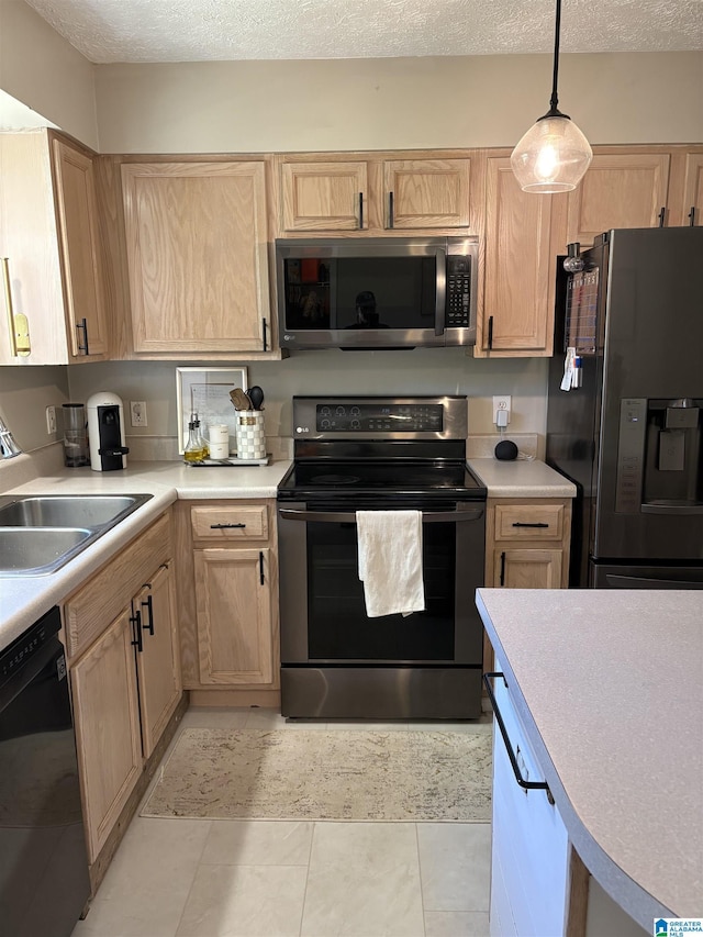 kitchen with black appliances, light brown cabinets, light countertops, and a sink