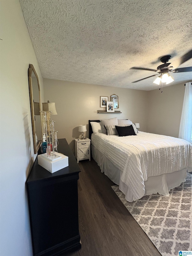 bedroom featuring a ceiling fan, a textured ceiling, and dark wood-type flooring