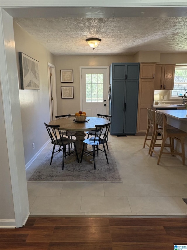 dining space featuring baseboards and a textured ceiling