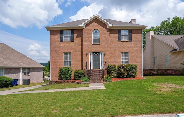 165 Ashford Ln, Alabaster, AL 35007 - colonial-style house with central AC unit, a chimney, a front lawn, and brick siding