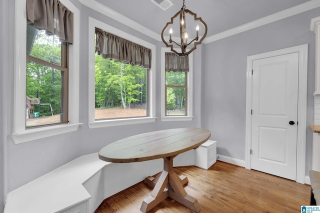 dining room with a chandelier, visible vents, a healthy amount of sunlight, and crown molding