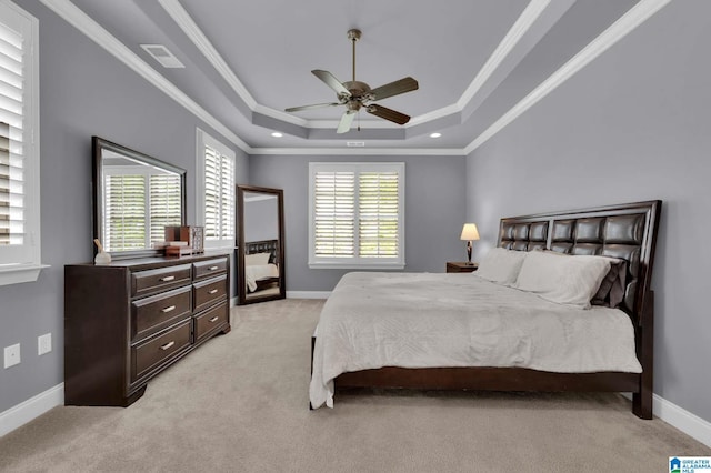 bedroom featuring visible vents, light carpet, crown molding, and a tray ceiling
