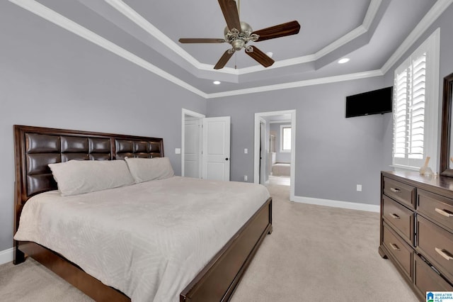 bedroom with ornamental molding, baseboards, light carpet, and a tray ceiling