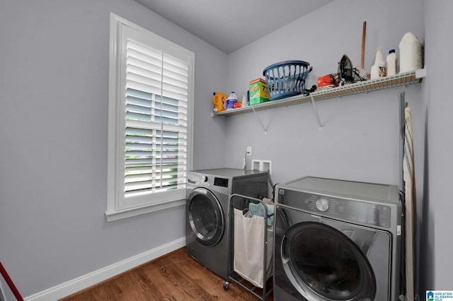 laundry area featuring laundry area, a healthy amount of sunlight, baseboards, washer and dryer, and wood finished floors