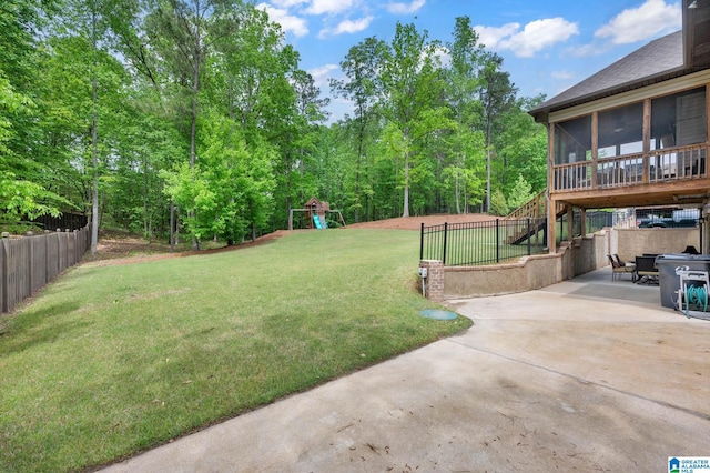 view of yard featuring a sunroom, stairway, a patio area, a playground, and fence