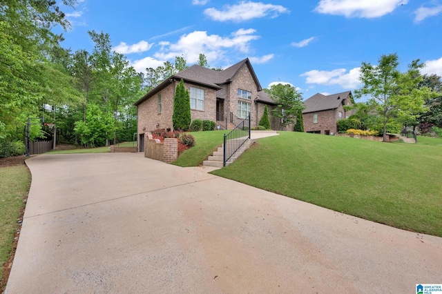 view of front of property featuring a front lawn, driveway, a garage, and brick siding