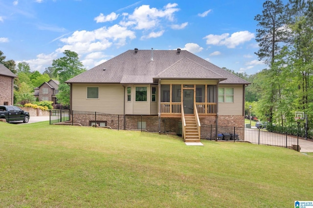 rear view of house featuring a fenced backyard, stairway, a yard, and a sunroom