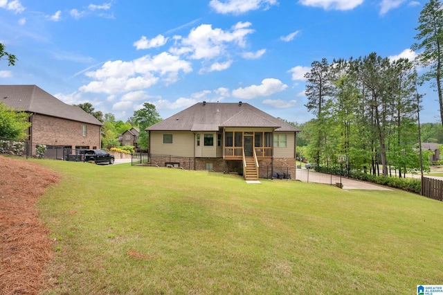 back of house featuring a sunroom, a yard, a shingled roof, and a fenced backyard