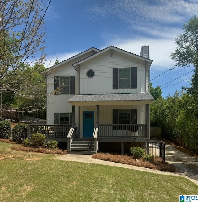 2607 Woodfern Ct, Homewood, AL 35209 - view of front of house with a front lawn, fence, a chimney, board and batten siding, and a porch