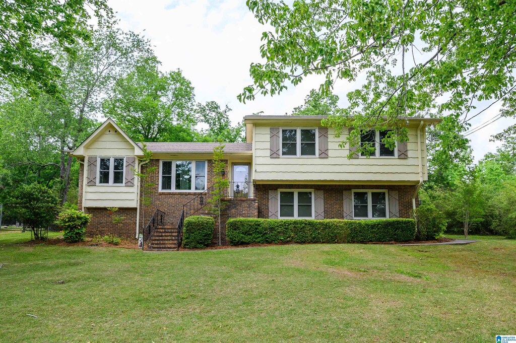 1030 Ivy Creek Trl, Hoover, AL 35226 - tri-level home with stairs, a front yard, and brick siding