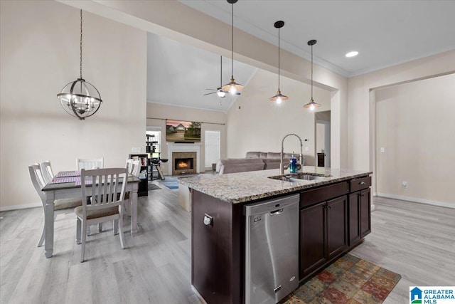 kitchen with dishwasher, a sink, baseboards, ceiling fan with notable chandelier, and light wood-style floors