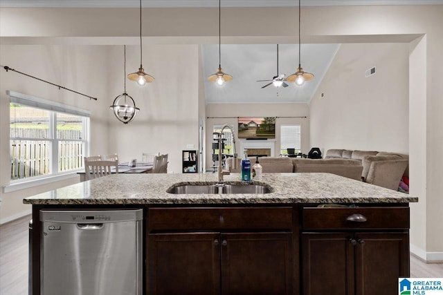 kitchen featuring dark brown cabinetry, a sink, ceiling fan with notable chandelier, stainless steel dishwasher, and vaulted ceiling