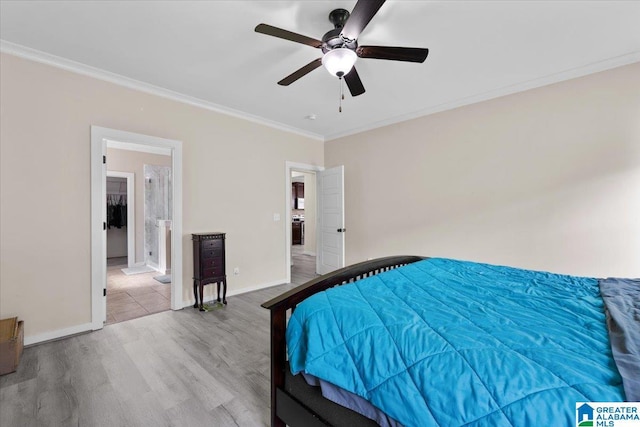 bedroom with connected bathroom, a ceiling fan, baseboards, wood finished floors, and ornamental molding