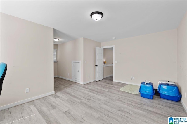 spare room with baseboards and wood finished floors