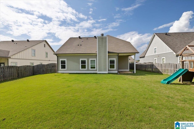 rear view of house with a fenced backyard, a playground, a yard, and a chimney