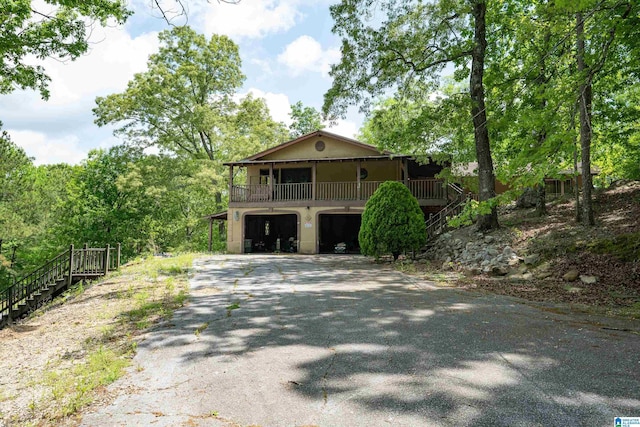 view of front facade with stairs, an attached garage, and driveway