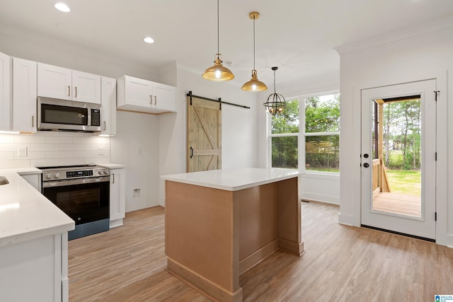 670 Hillstone Dr, Pell City, AL 35125 - kitchen with decorative backsplash, a barn door, stainless steel appliances, white cabinets, and light wood finished floors