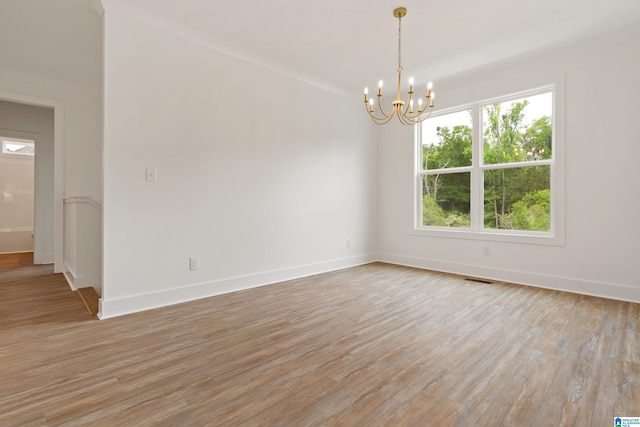 670 Hillstone Dr, Pell City, AL 35125 - spare room featuring an inviting chandelier, light wood-style floors, plenty of natural light, and baseboards