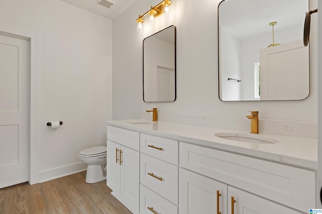 670 Hillstone Dr, Pell City, AL 35125 - full bathroom featuring toilet, double vanity, a sink, and wood finished floors