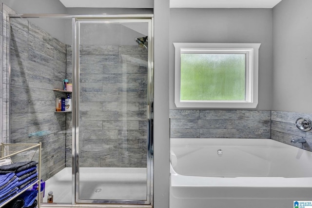 full bathroom featuring a bath and a shower stall