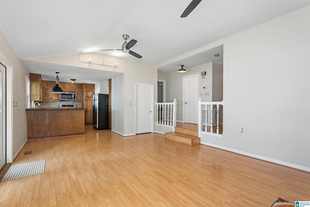 3516 Griffitt Bend Rd, Talladega, AL 35160 - unfurnished living room with a ceiling fan, light wood-style floors, vaulted ceiling, baseboards, and stairs
