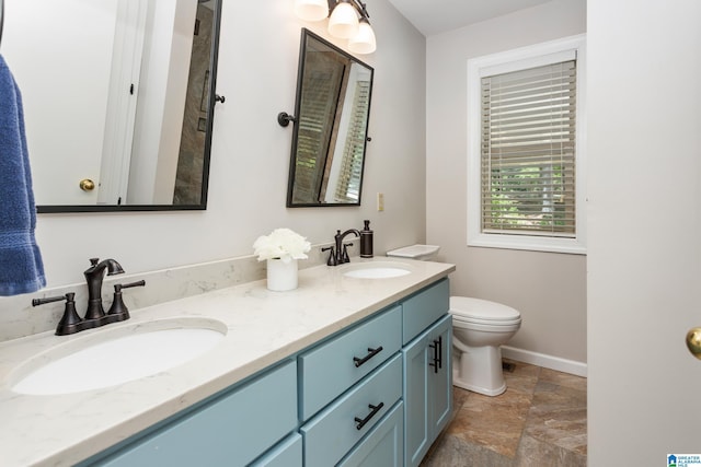 3516 Griffitt Bend Rd, Talladega, AL 35160 - bathroom featuring stone tile flooring, toilet, double vanity, and baseboards