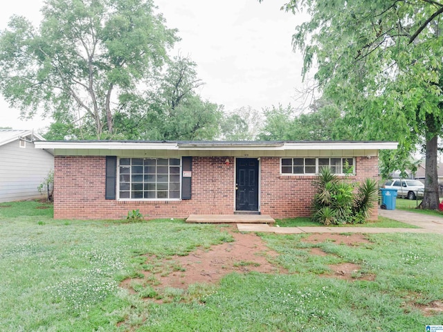 single story home with a front yard and brick siding