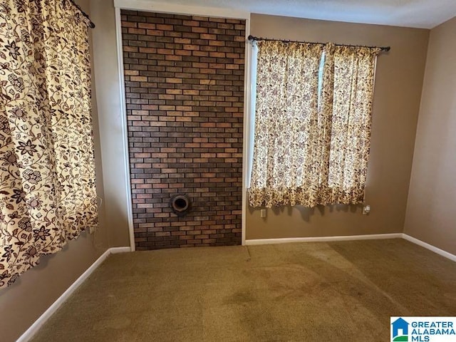 carpeted empty room featuring baseboards