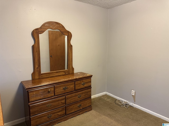 bedroom featuring a textured ceiling, carpet, and baseboards