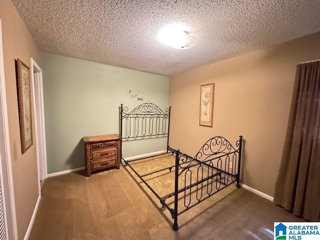 bedroom featuring a textured ceiling, carpet, and baseboards