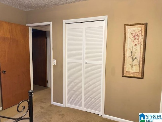 unfurnished bedroom with a closet, carpet floors, and baseboards