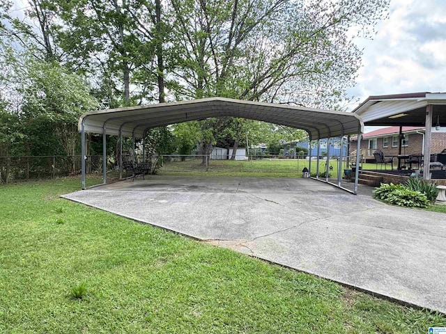view of parking / parking lot featuring fence, a detached carport, and driveway