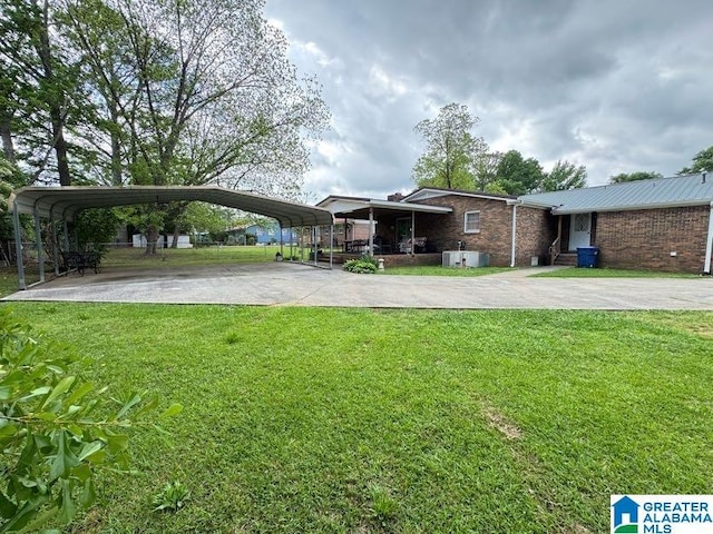 view of front facade with brick siding, a detached carport, a front lawn, and driveway