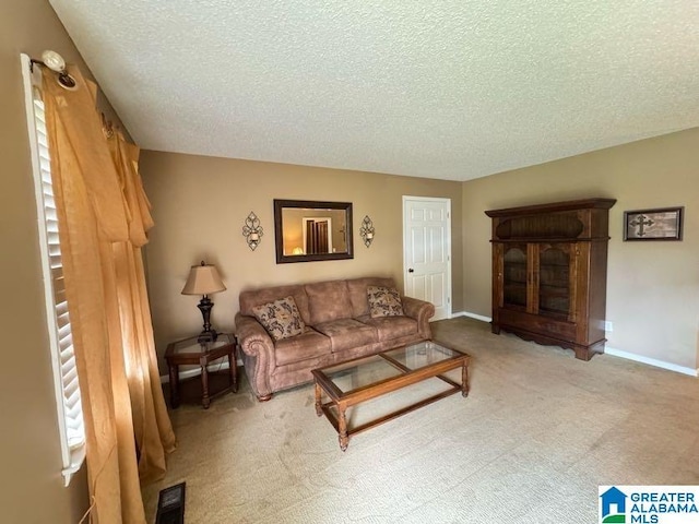 living area with baseboards, visible vents, a textured ceiling, and carpet