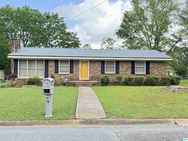 single story home with a chimney, metal roof, a front yard, and brick siding