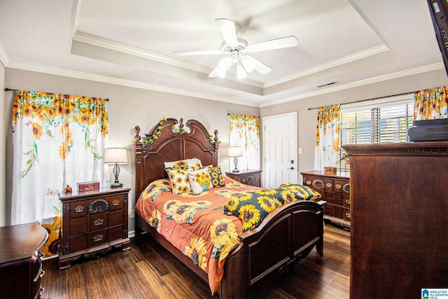 bedroom featuring visible vents, crown molding, ceiling fan, a raised ceiling, and dark wood finished floors