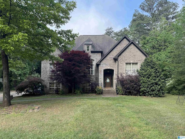 french country home with a front lawn and stone siding