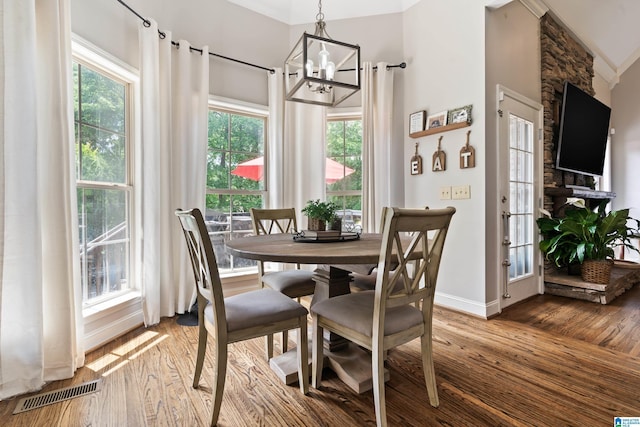 dining area featuring wood finished floors, a chandelier, and baseboards