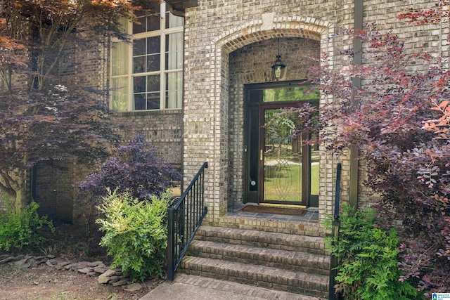 doorway to property featuring brick siding