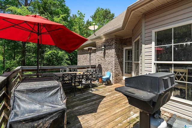 wooden terrace featuring outdoor dining space and a grill