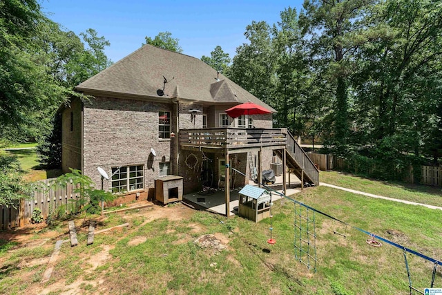 rear view of property with a deck, brick siding, stairs, a patio, and roof with shingles