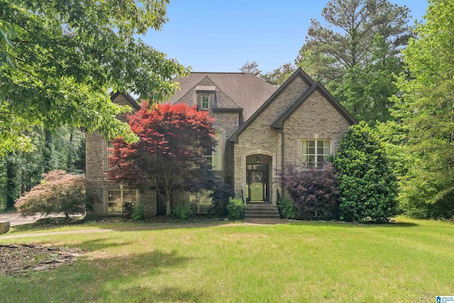view of front of property with a front lawn and brick siding