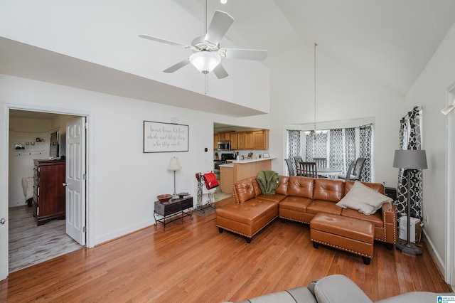 20443 Hepzibah Church Rd, Mccalla, AL 35111 - living room with baseboards, light wood finished floors, ceiling fan with notable chandelier, and high vaulted ceiling