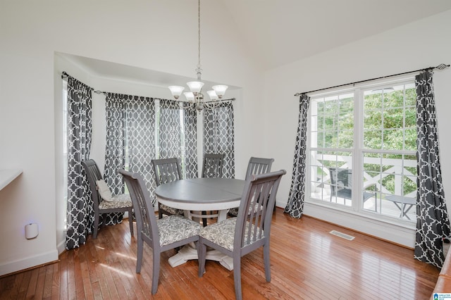 20443 Hepzibah Church Rd, Mccalla, AL 35111 - dining space with a chandelier, baseboards, vaulted ceiling, visible vents, and hardwood / wood-style flooring