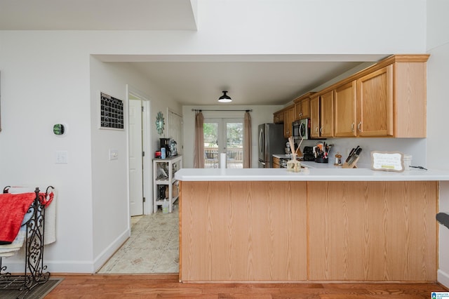20443 Hepzibah Church Rd, Mccalla, AL 35111 - kitchen featuring appliances with stainless steel finishes, light countertops, baseboards, a peninsula, and light wood-style floors